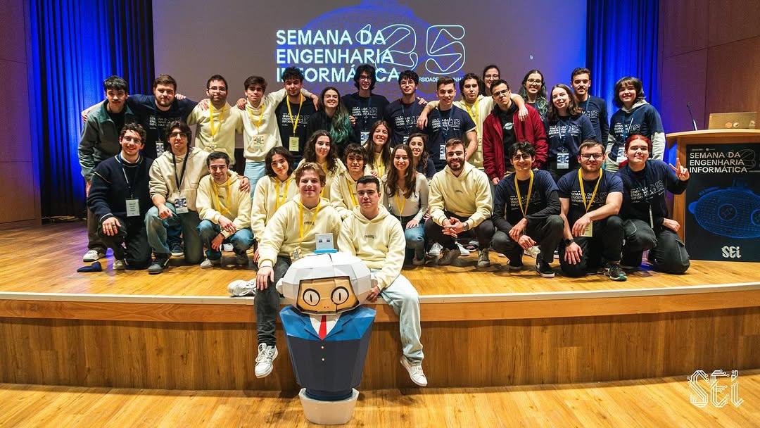 Universidade do MinhoGrupo de estudantes do CeSIUM reunidos no palco durante a Semana da Engenharia Informática, com um mascote Void.